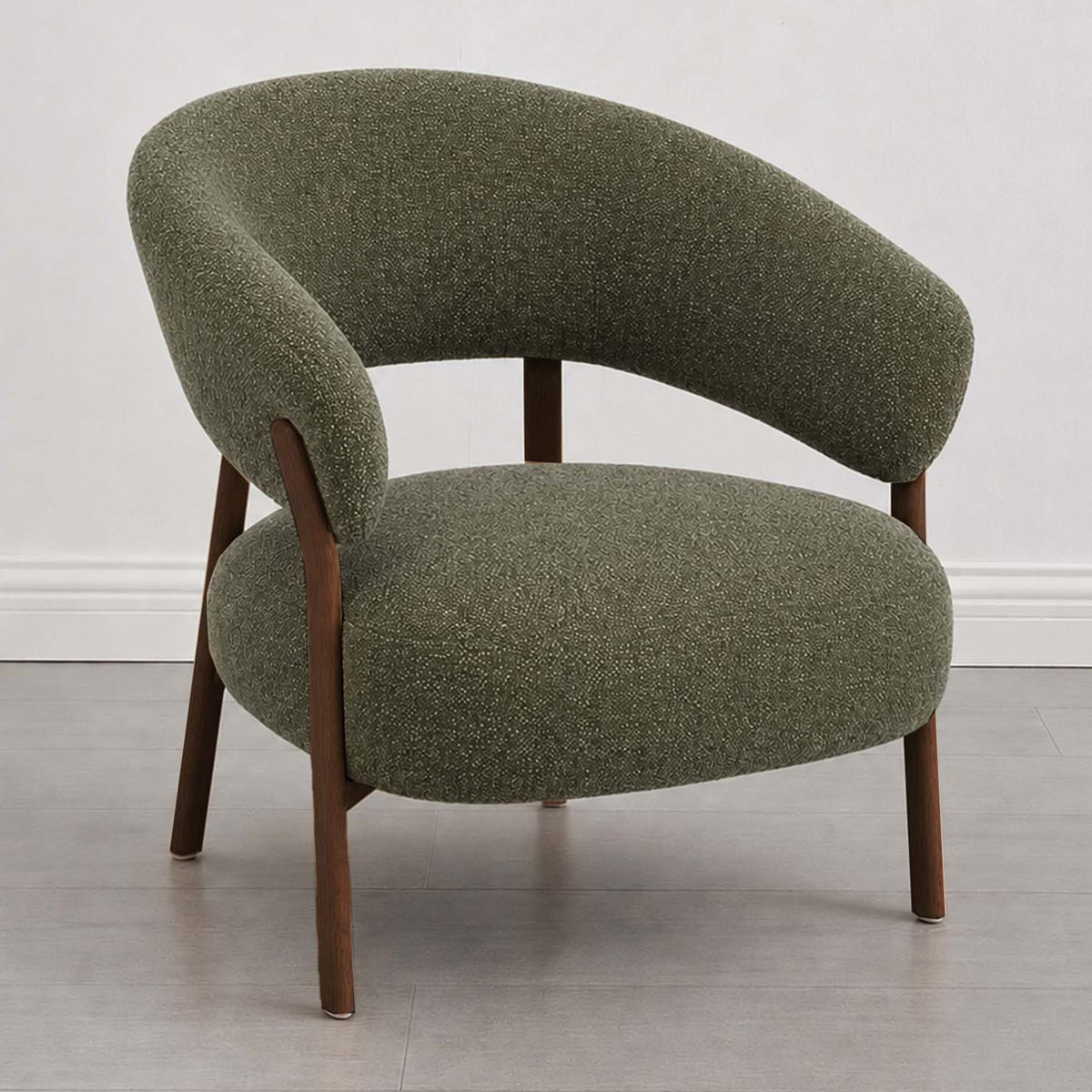 A modern barrel-style armchair with a textured olive green bouclé upholstery and dark brown wooden legs, shown against a neutral light gray wall and floor.