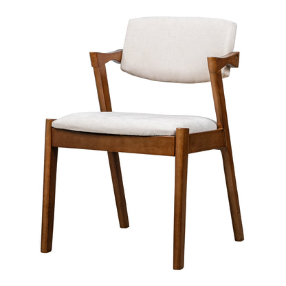 A mid-century modern dining chair with a warm brown wooden frame and light beige upholstered seat and backrest, shown on a solid white background.