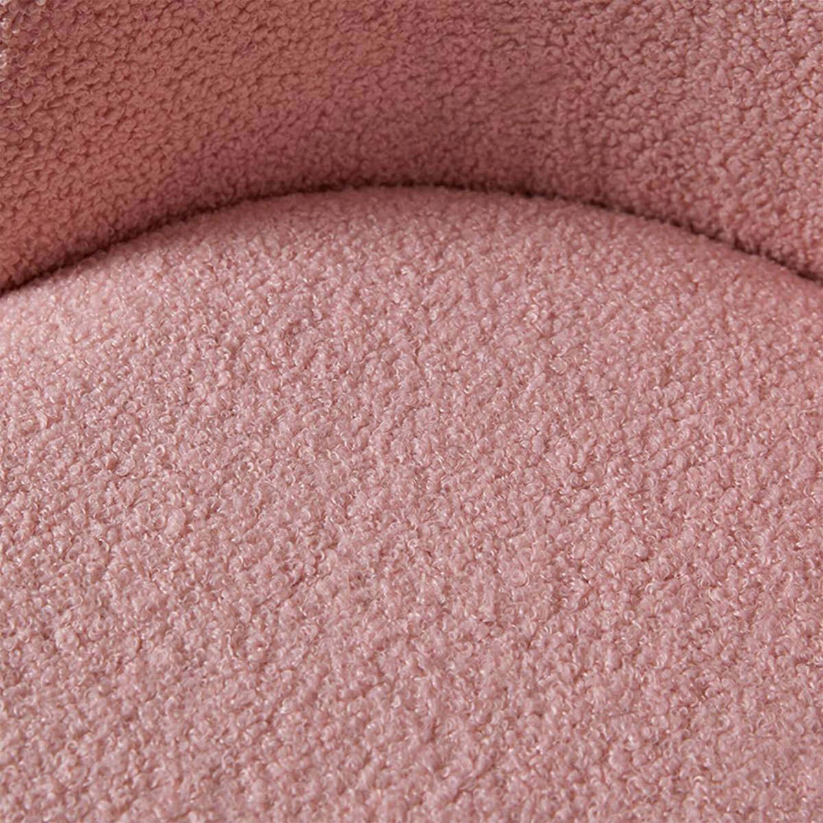 A close-up of a dusty pink textured fabric, showing the looped pile of a chair or cushion.