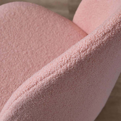 Close-up of a pink textured upholstered chair or sofa corner, showing the fabric weave and curved seat/back edge against a softly blurred neutral background.