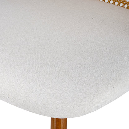 Close-up of a light beige textured fabric upholstered chair seat with a wooden leg visible at the bottom and part of a gold metal frame at the top edge.