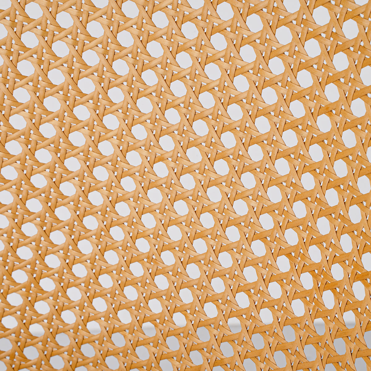 A close-up of a woven cane or rattan panel with a repeating geometric pattern of interlaced light tan strips and circular cutouts.