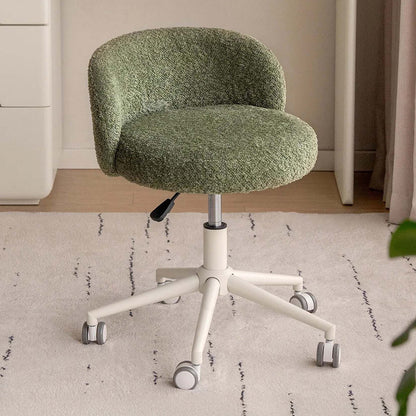 A small upholstered office chair with a textured sage green boucle-style seat and curved back, mounted on a white five-star wheeled base with a black lever, shown in a home office setting on a light rug.